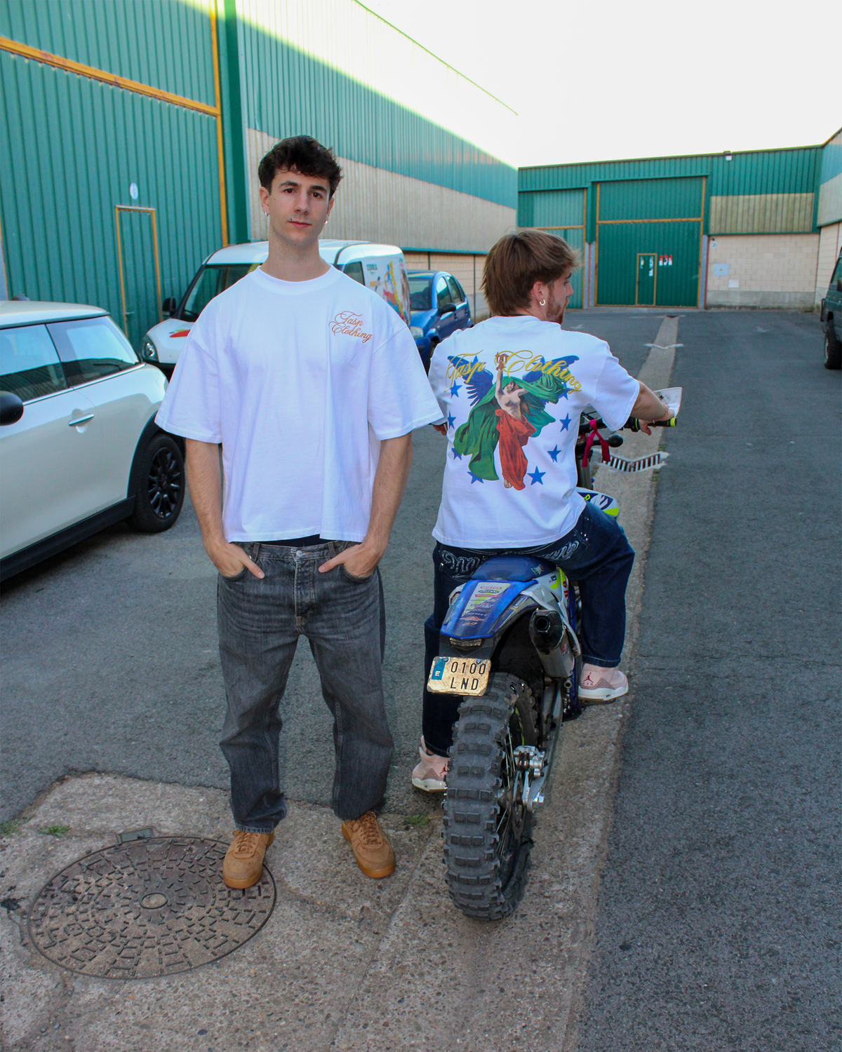 Dos modelos con la camiseta blanca ANGEL de TASP Clothing, vista frontal y trasera, junto a una moto